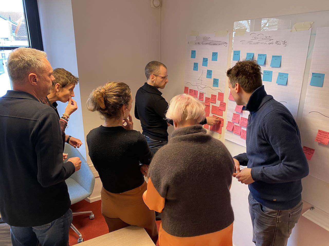 Deelnemers bespreken ideeën en post-its tijdens een workshop