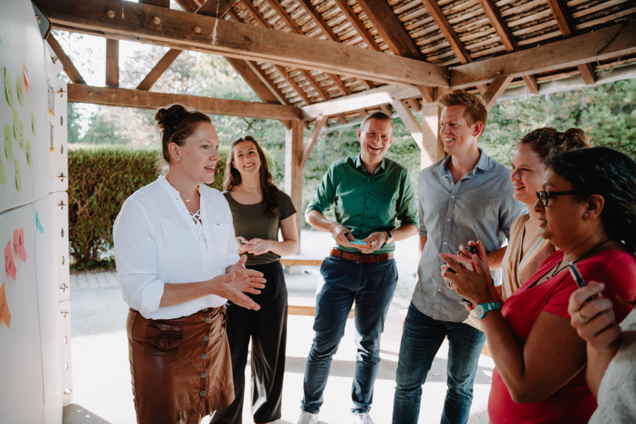 Een groep werkt samen bij een bord met post-its tijdens een workshop
